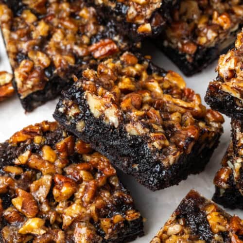 Several pecan pie brownies scattered on a serving tray.