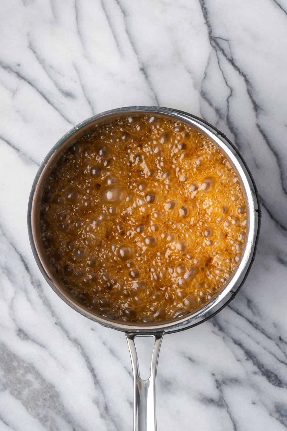 Caramel mixture bubbling in a saucepan.