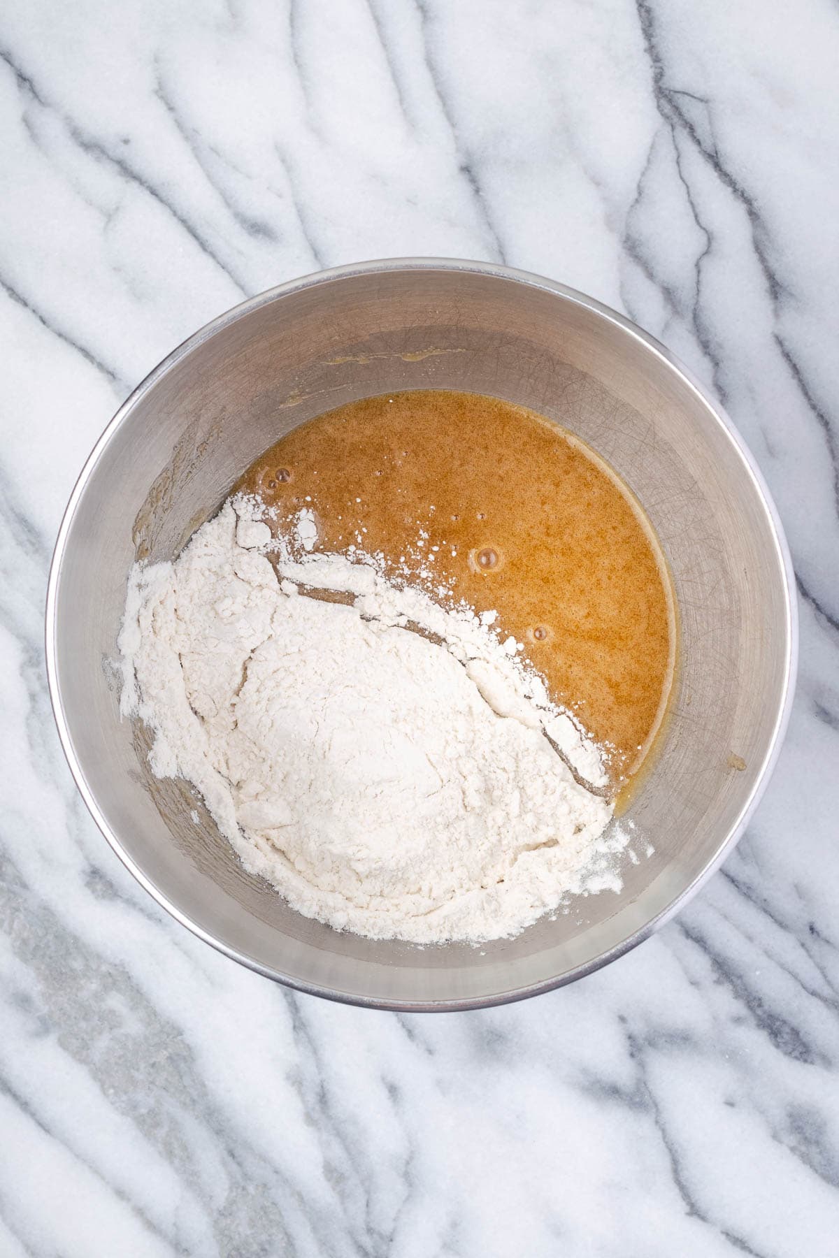 Dry ingredients being added to the mixing bowl with the wet ingredients.
