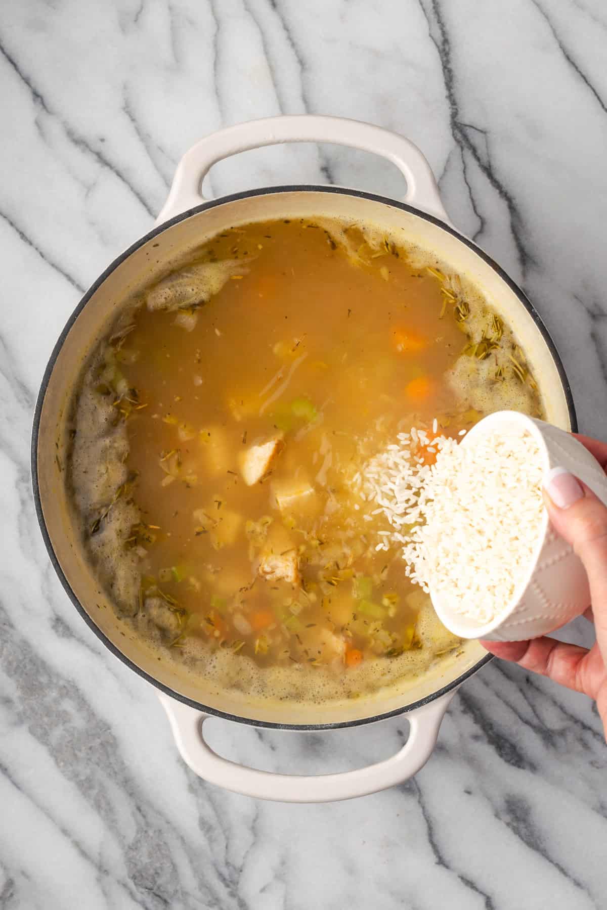 Rice being poured into the soup pot.