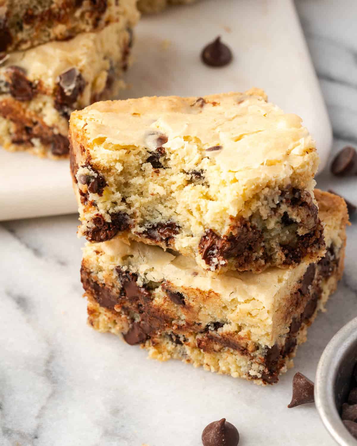 A white chocolate blondie with a bite taken out sitting on a counter. 