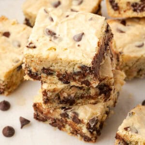 A stack of three white chocolate blondies sitting on a marble board.