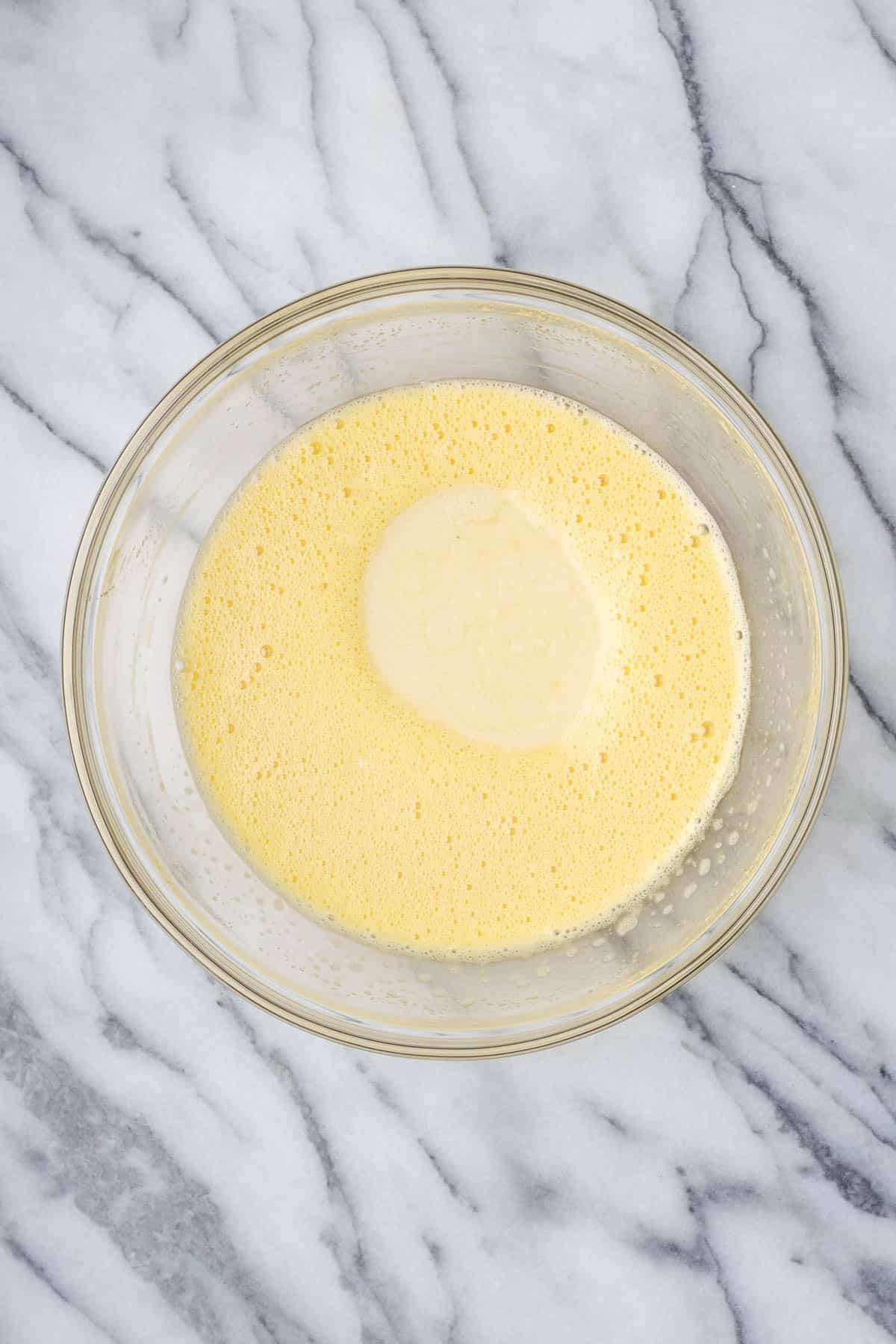 Melted white chocolate poured into the bowl with the egg mixture.