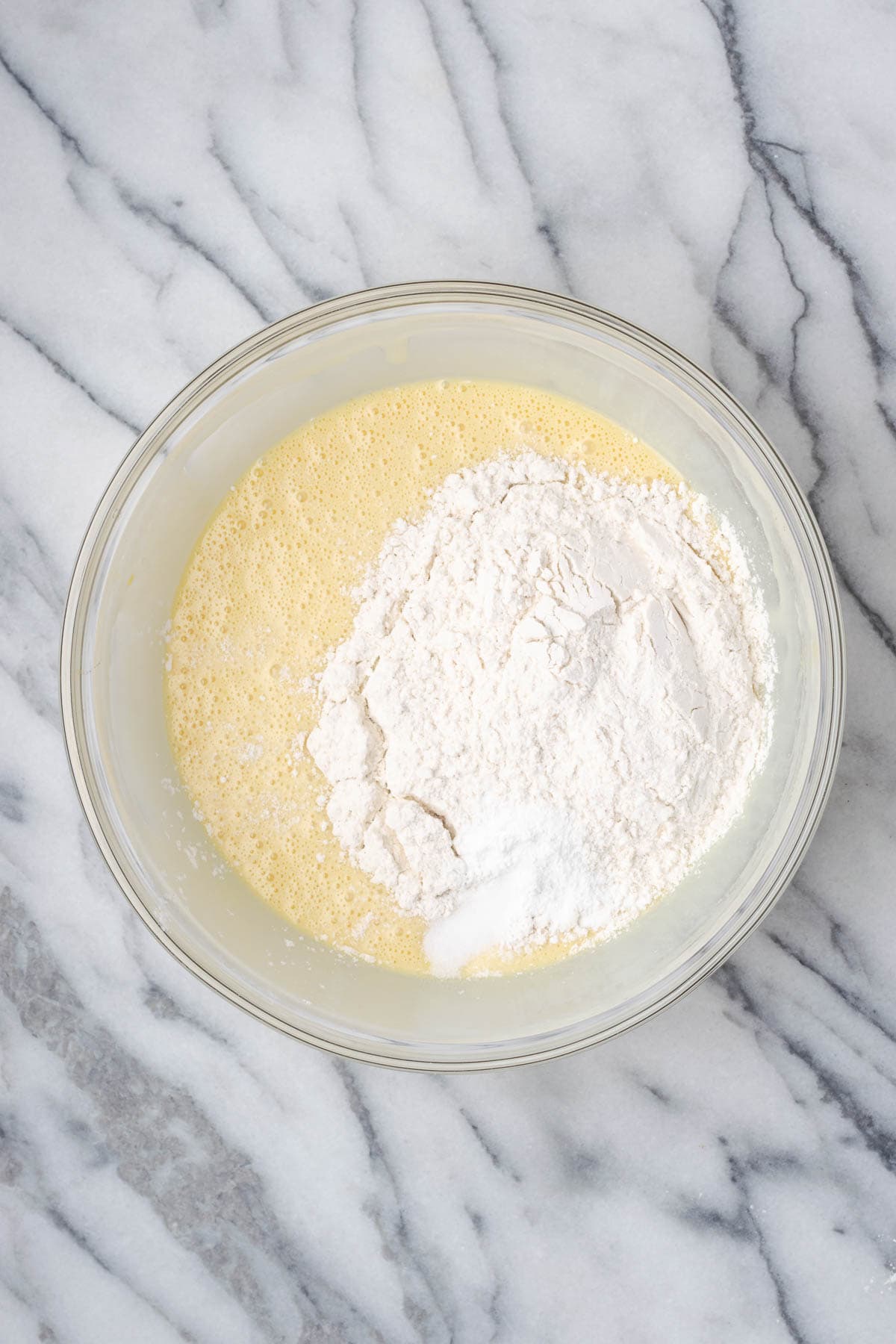 Flour, baking powder, and salt added into the bowl with the wet ingredients.  