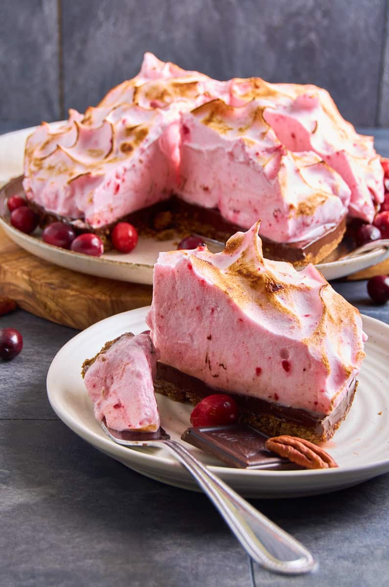 A chocolate tart topped with a pink colored cranberry meringue.