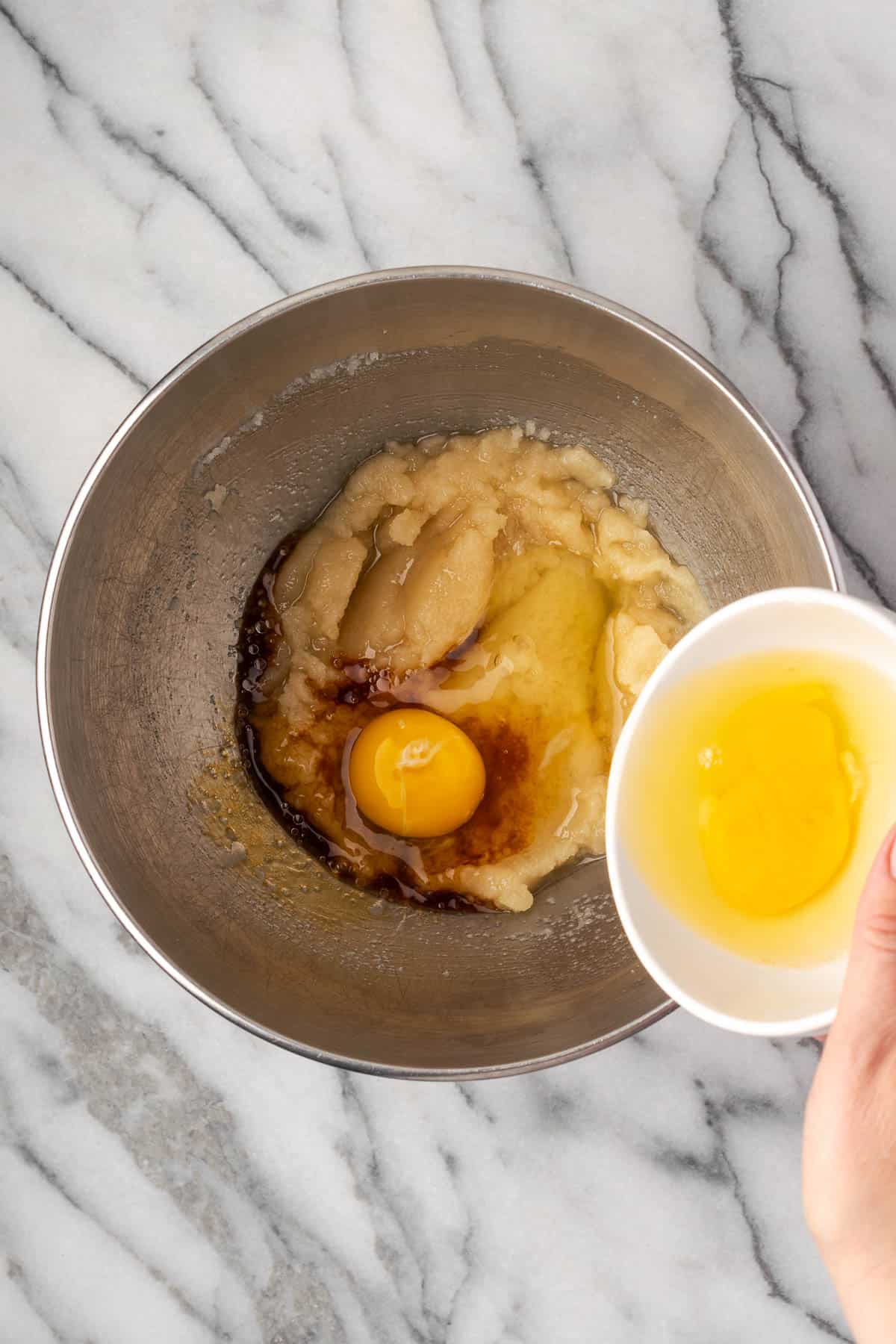 Vanilla and eggs being added to the sugar mixture. 