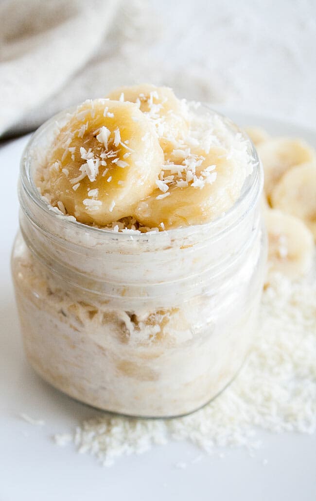 Banana cream pie overnight oats served in a small jar.