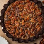 A chocolate pecan pie sitting on a brown table.