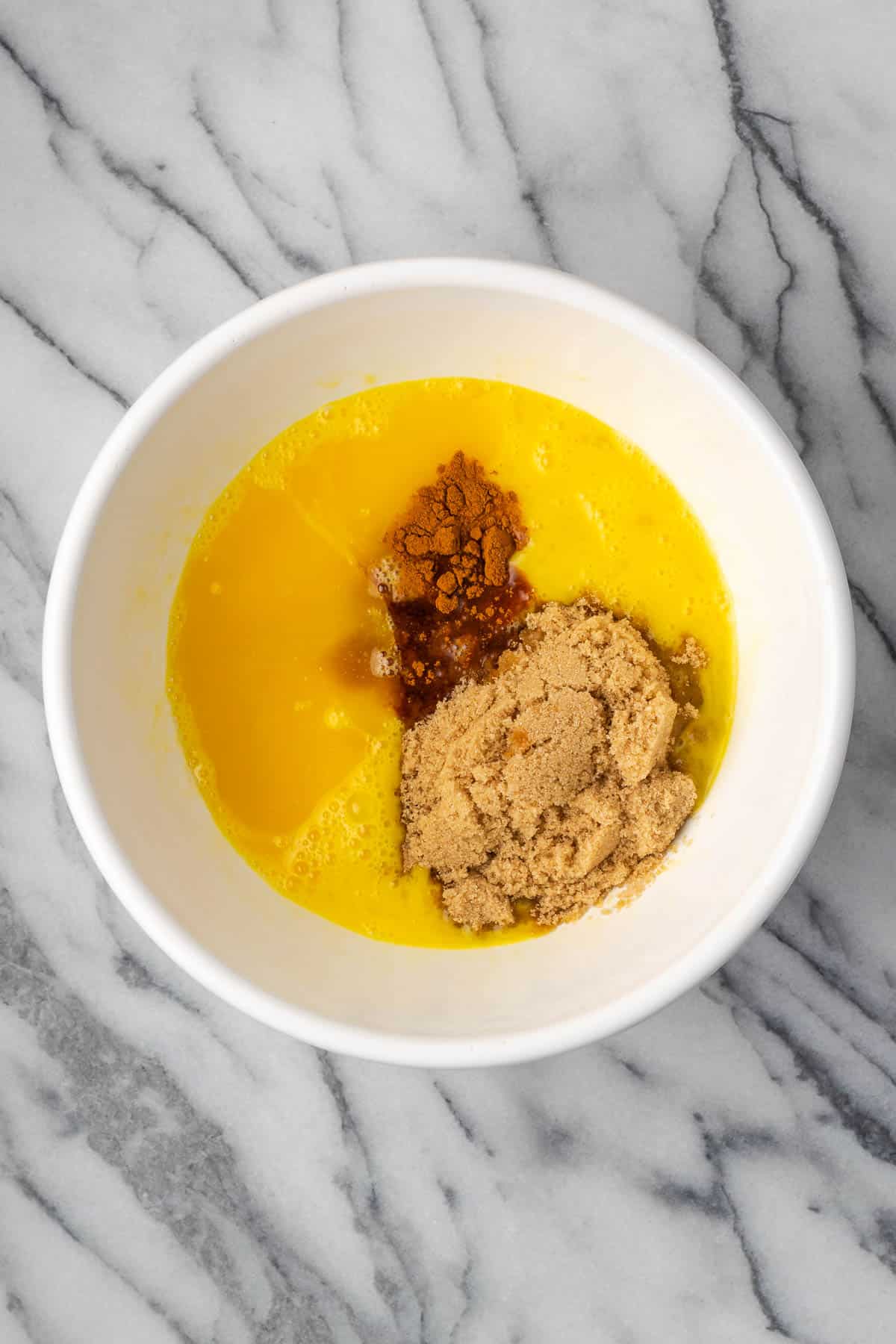 Brown sugar, corn syrups, melted butter, vanilla, salt and cinnamon added to the bowl with the beaten eggs.