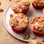 Several cranberry sauce muffins served on a ceramic plate.