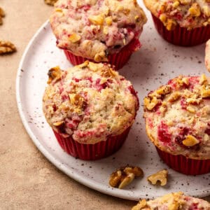 Several cranberry sauce muffins served on a ceramic plate.