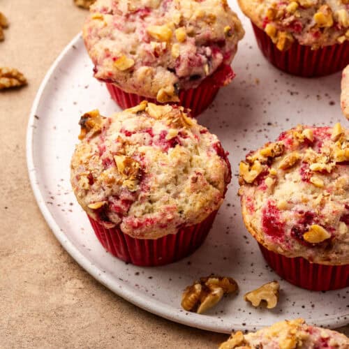 Several cranberry sauce muffins served on a ceramic plate.