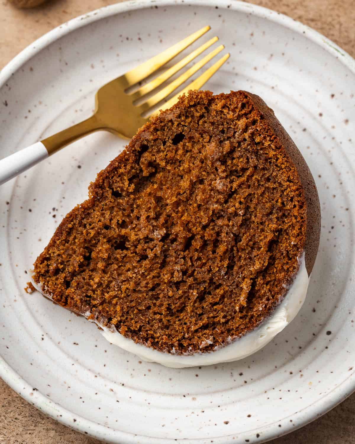 A slice of gingerbread cake on a small ceramic plate.
