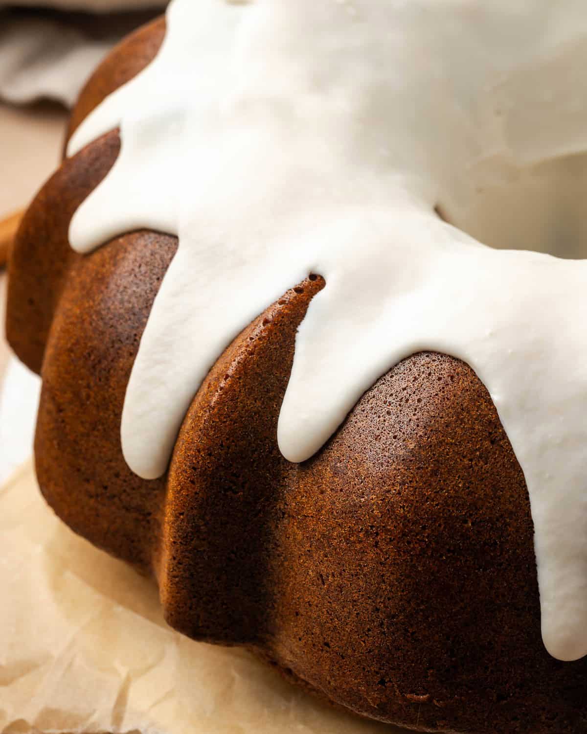 A gingerbread bundt cake covered with white chocolate ganache icing.