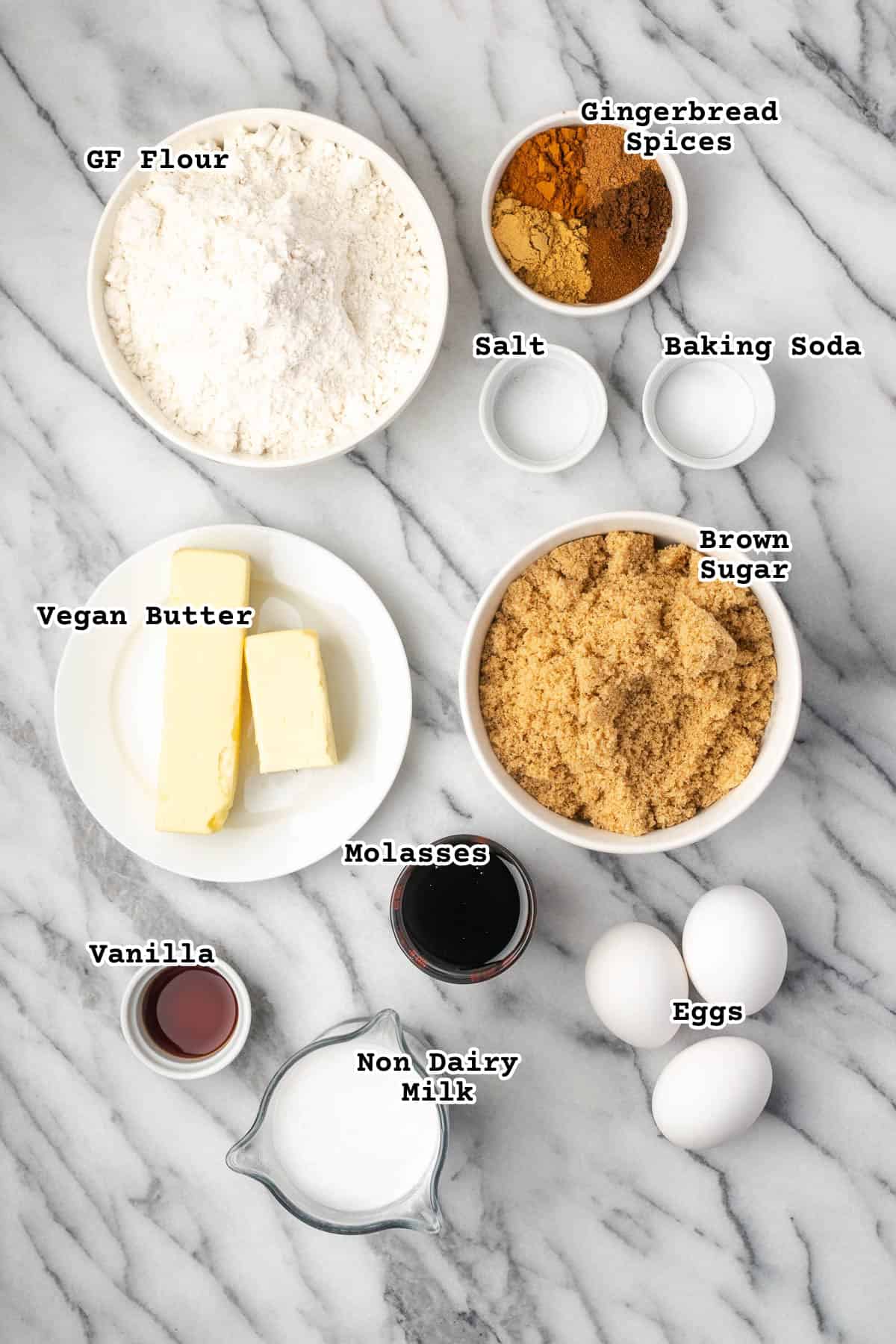 Ingredients for a gingerbread bundt cake sitting on a marble counter.