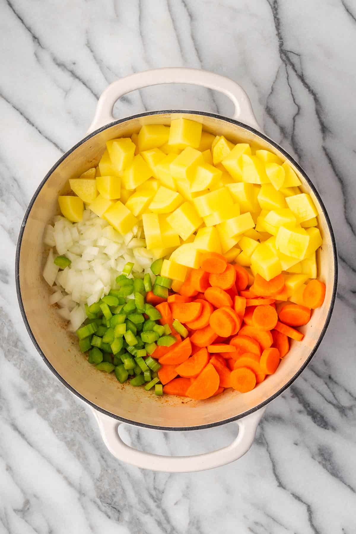 Potatoes, onions, celery and carrots in a large soup pot. 