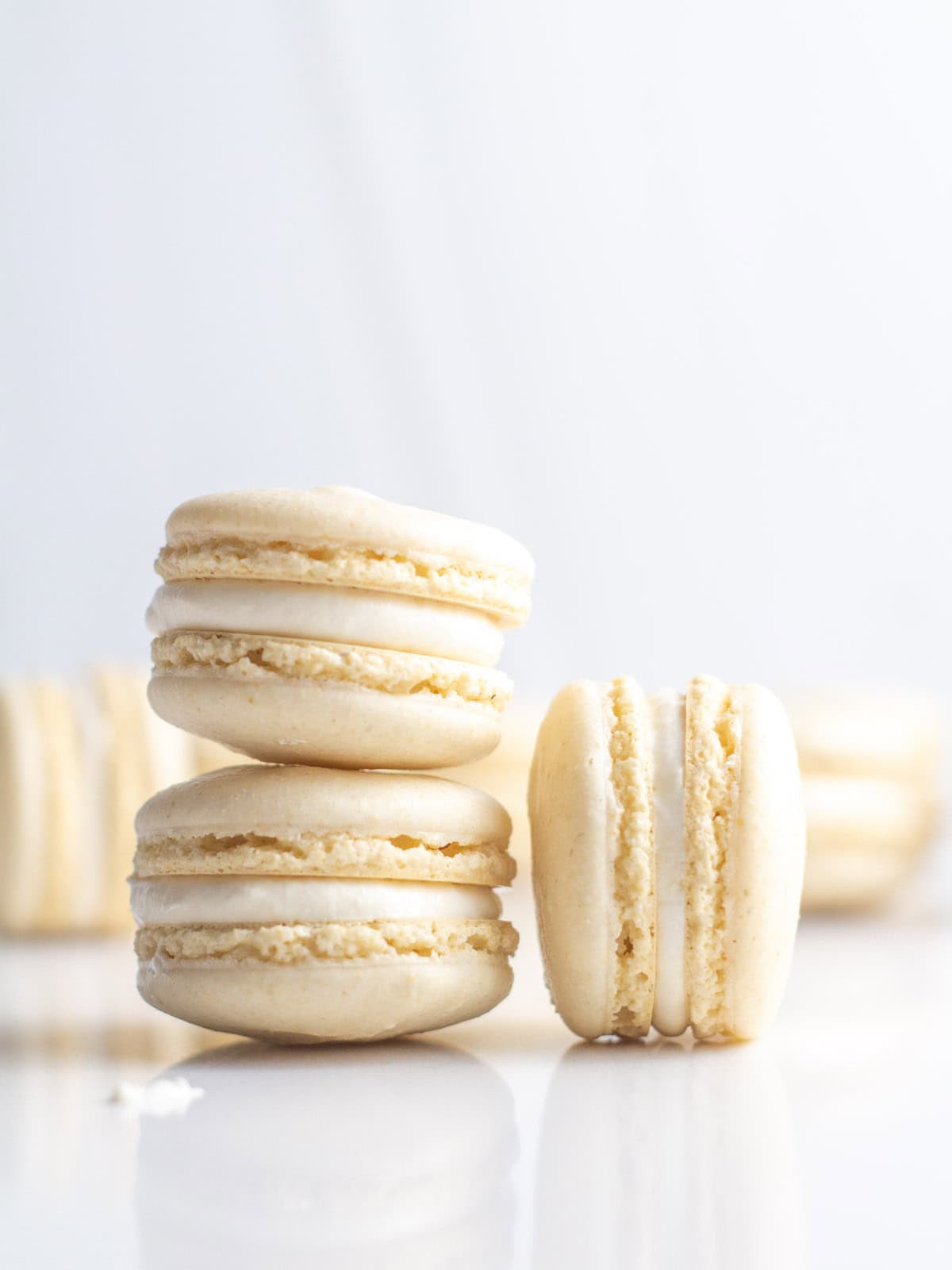 Three oat flour macarons stacked on a marble countertop.