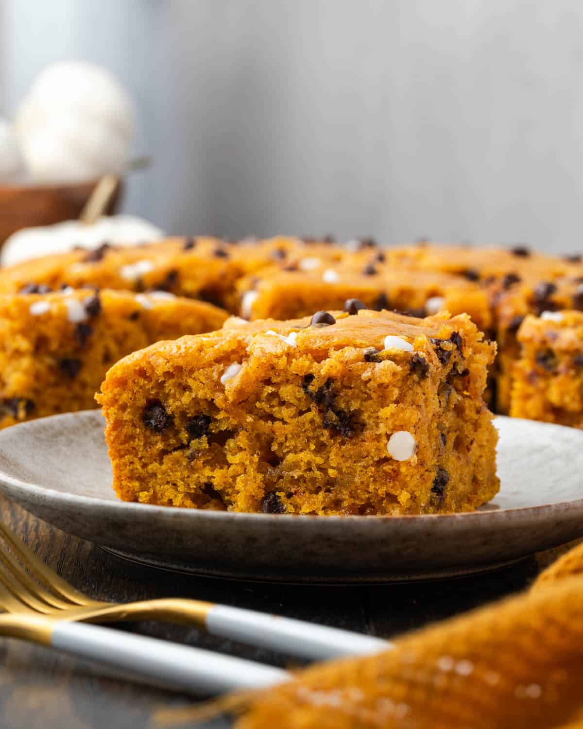 A slice of pumpkin chocolate chip cake on a small dessert plate. 