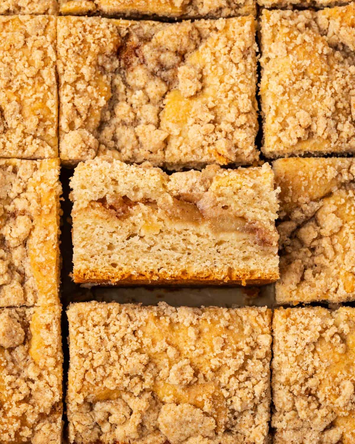 Several slices of apple cinnamon coffee cake sitting on a marble counter.