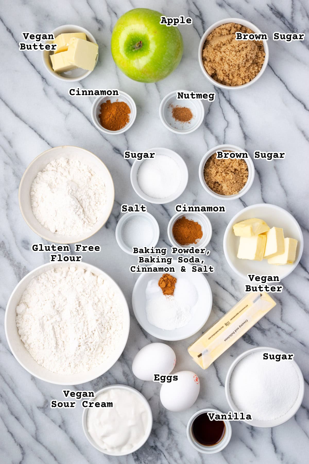 Ingredients for a gluten free apple coffee cake on a marble counter.