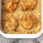 A pan of baked chicken and rice casserole sitting on a marble counter.