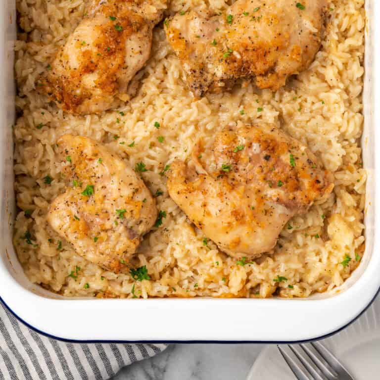 A pan of baked chicken and rice casserole sitting on a marble counter.