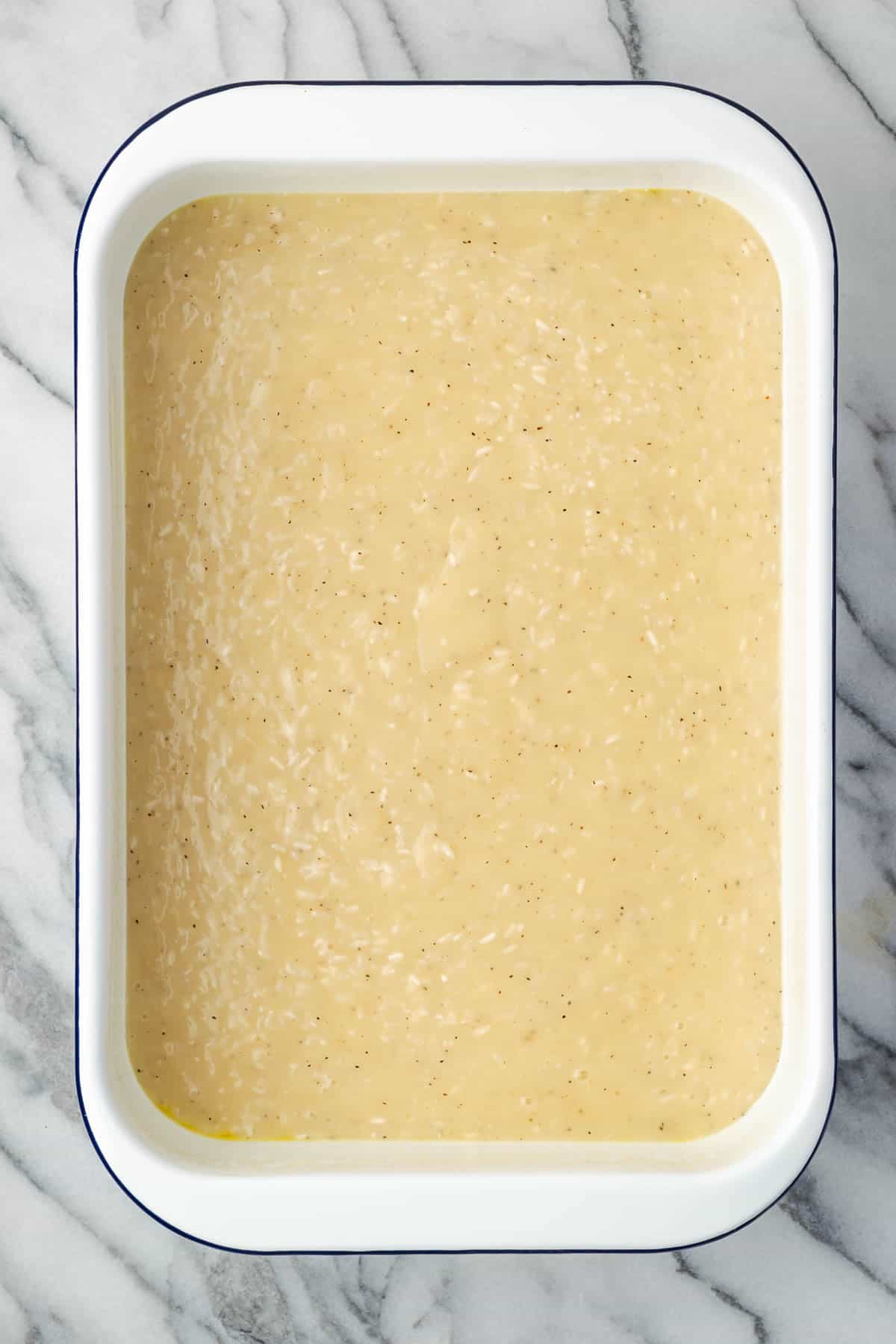 Rice and cream sauce poured into a casserole dish. 