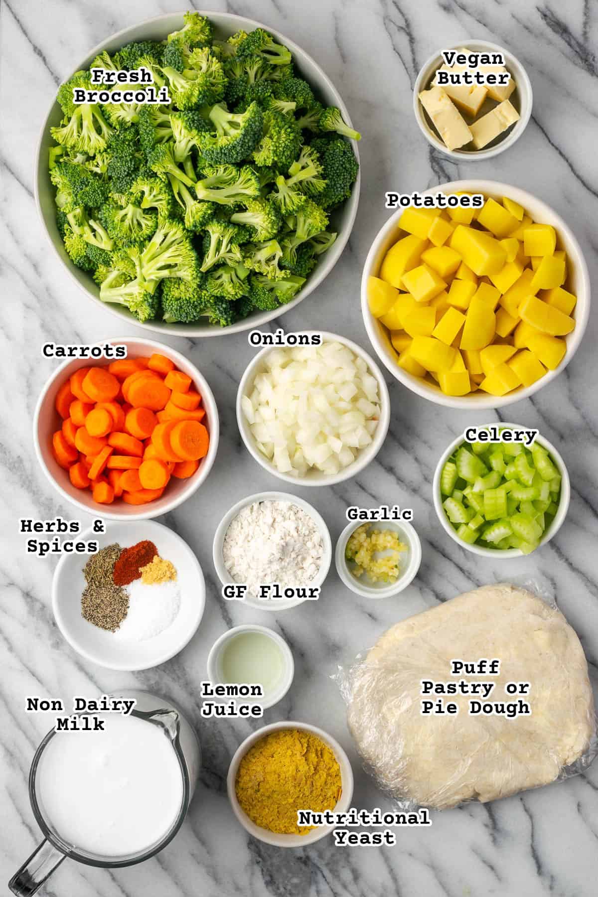 Ingredients for a veggie pot pie sitting on a marble counter.