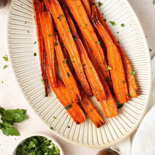 Maple glazed carrots served on a large ceramic platter.