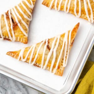 Several apple turnovers on a metal tray.