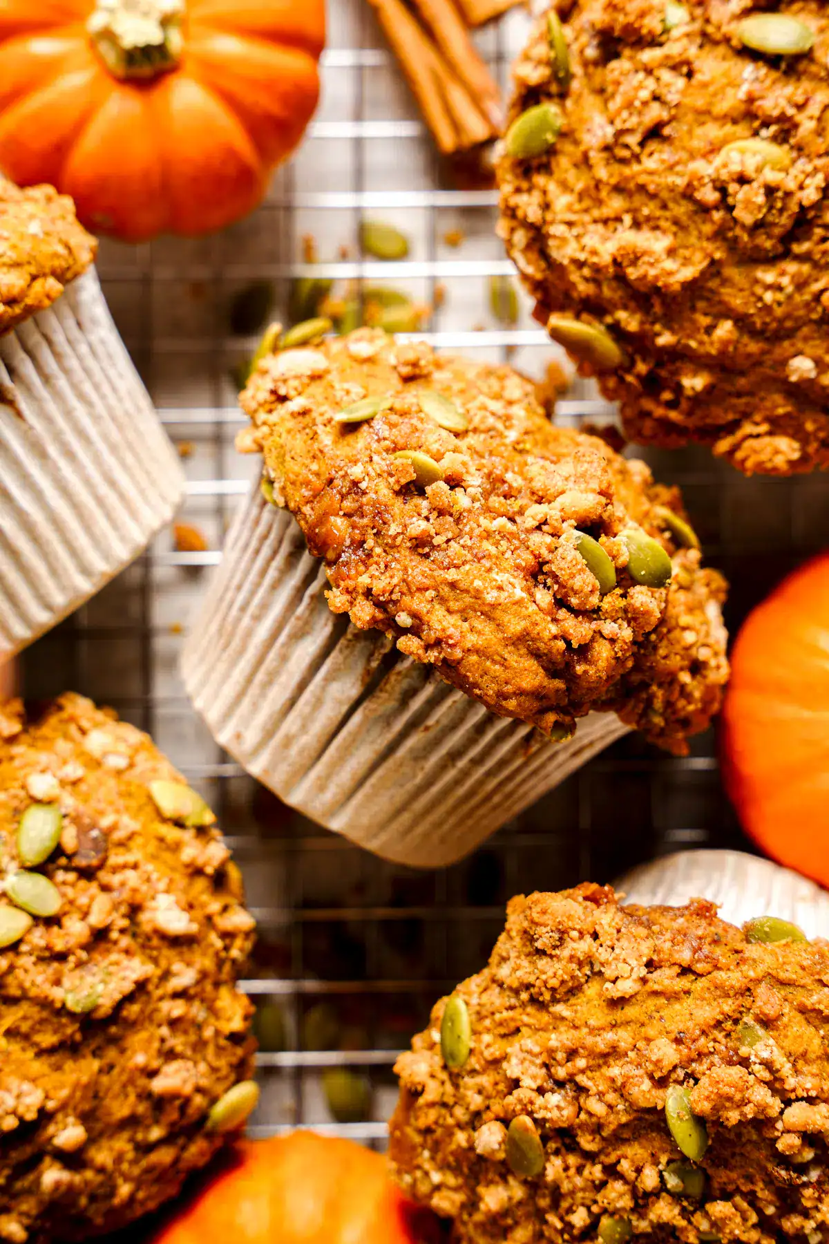A batch of oat flour pumpkin muffins scattered on a wire cooling rack.