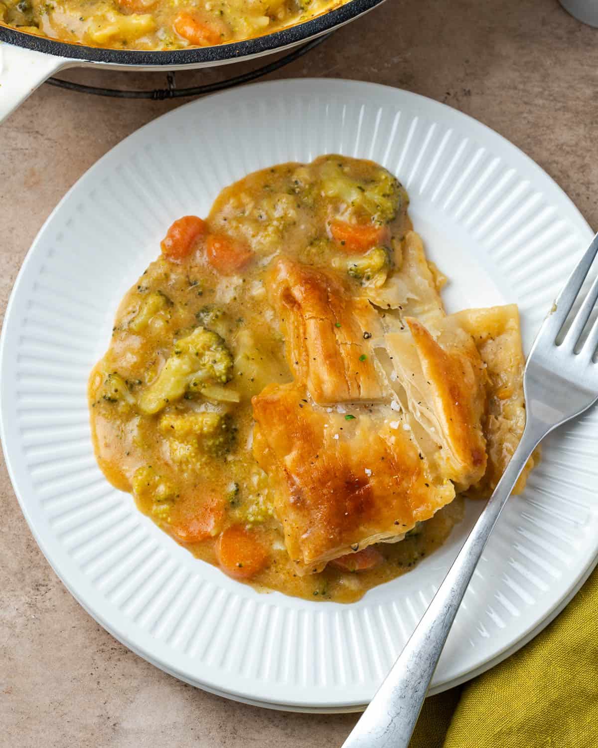 A serving of broccoli and cheese pot pie on a small dinner plate.