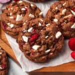 Several chocolate raspberry cookies sitting on a wood tray.