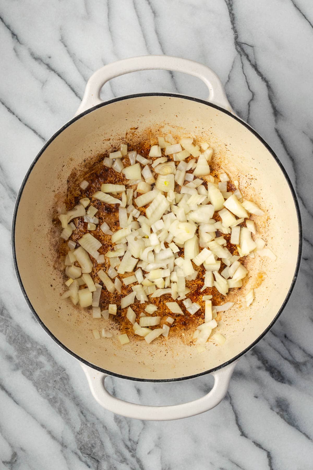 Onions being sauteed in a large pot.