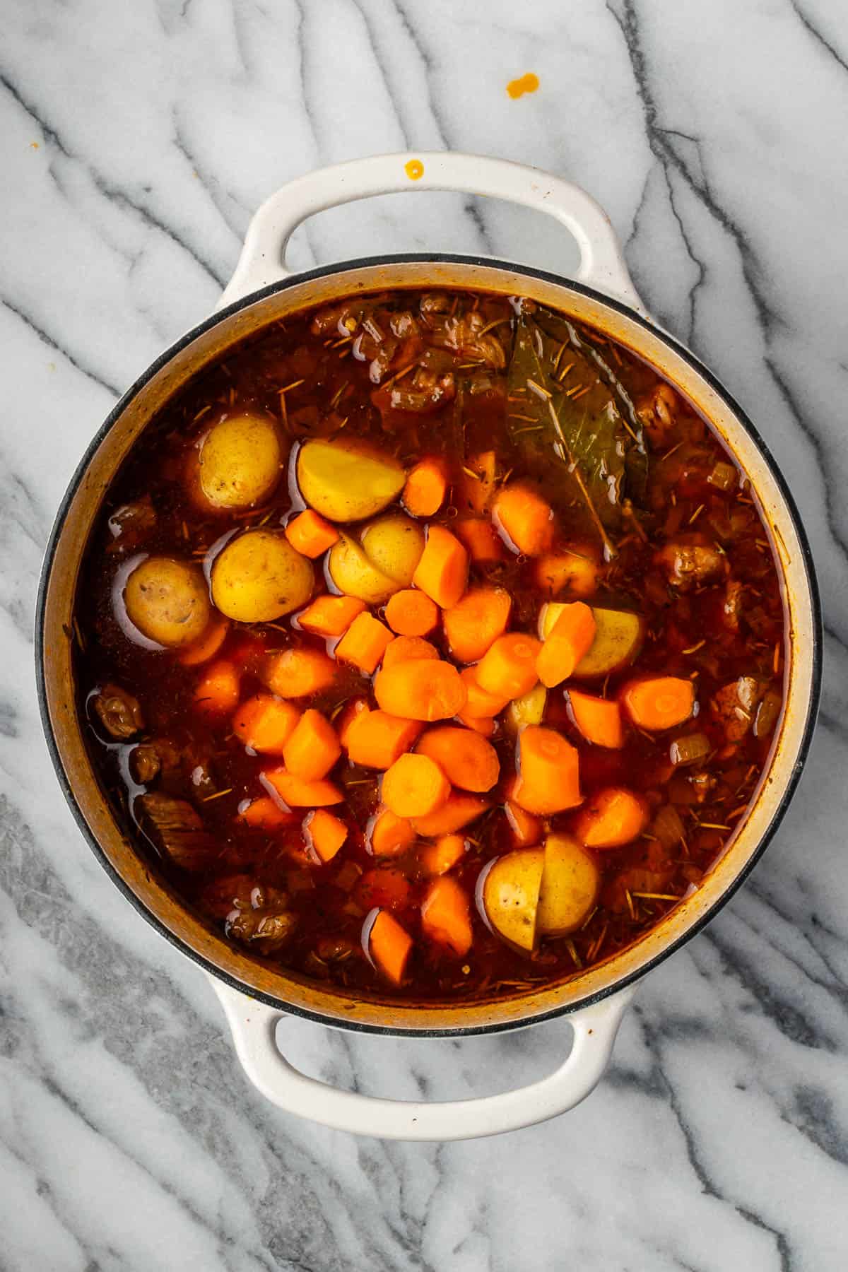 Carrots and potatoes added to the pot with the cooked beef.