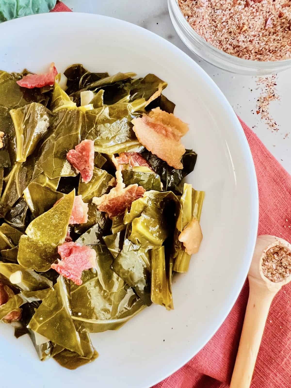 A bowl of collard greens sitting on a white table.