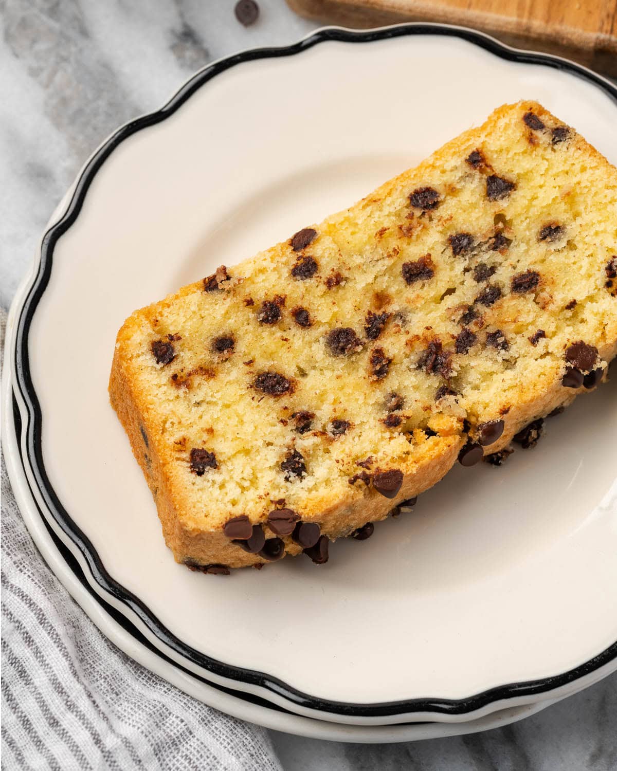 A slice of chocolate chip pound cake on a small serving plate.