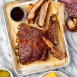 BBQ spareribs served on a small metal tray.