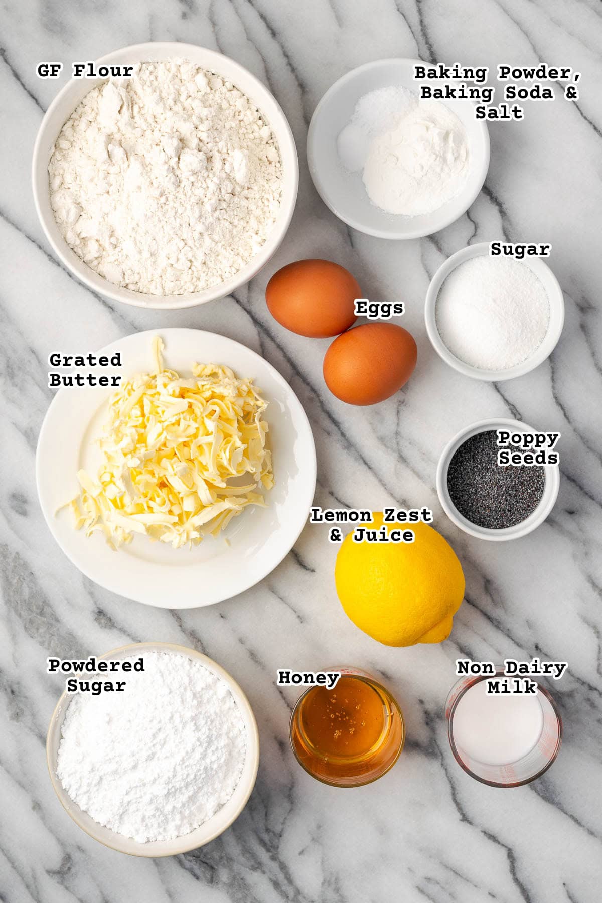 Ingredients for lemon poppy seed scones sitting on a marble counter.