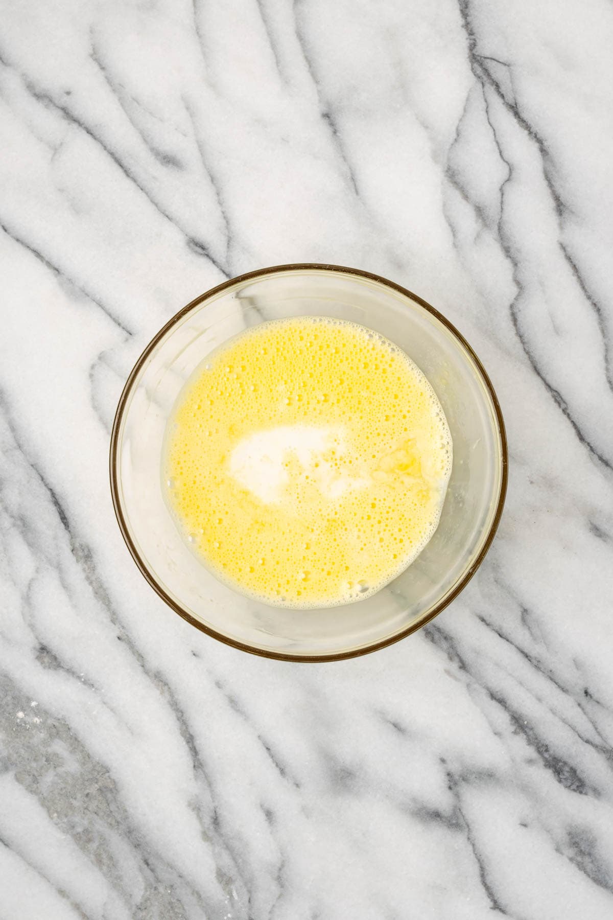 Milk, honey, and lemon juice added in to the bowl with the beaten eggs.