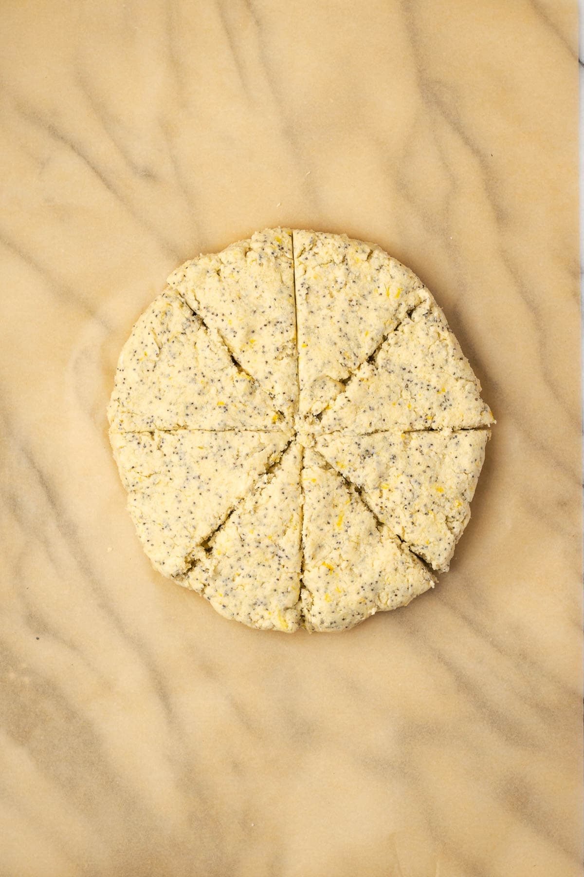 Scone dough patted into a circle and cut into eight wedges.