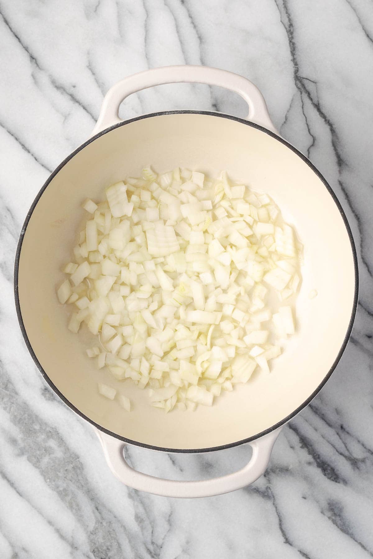 Diced onions being sauteed in a large pot. 