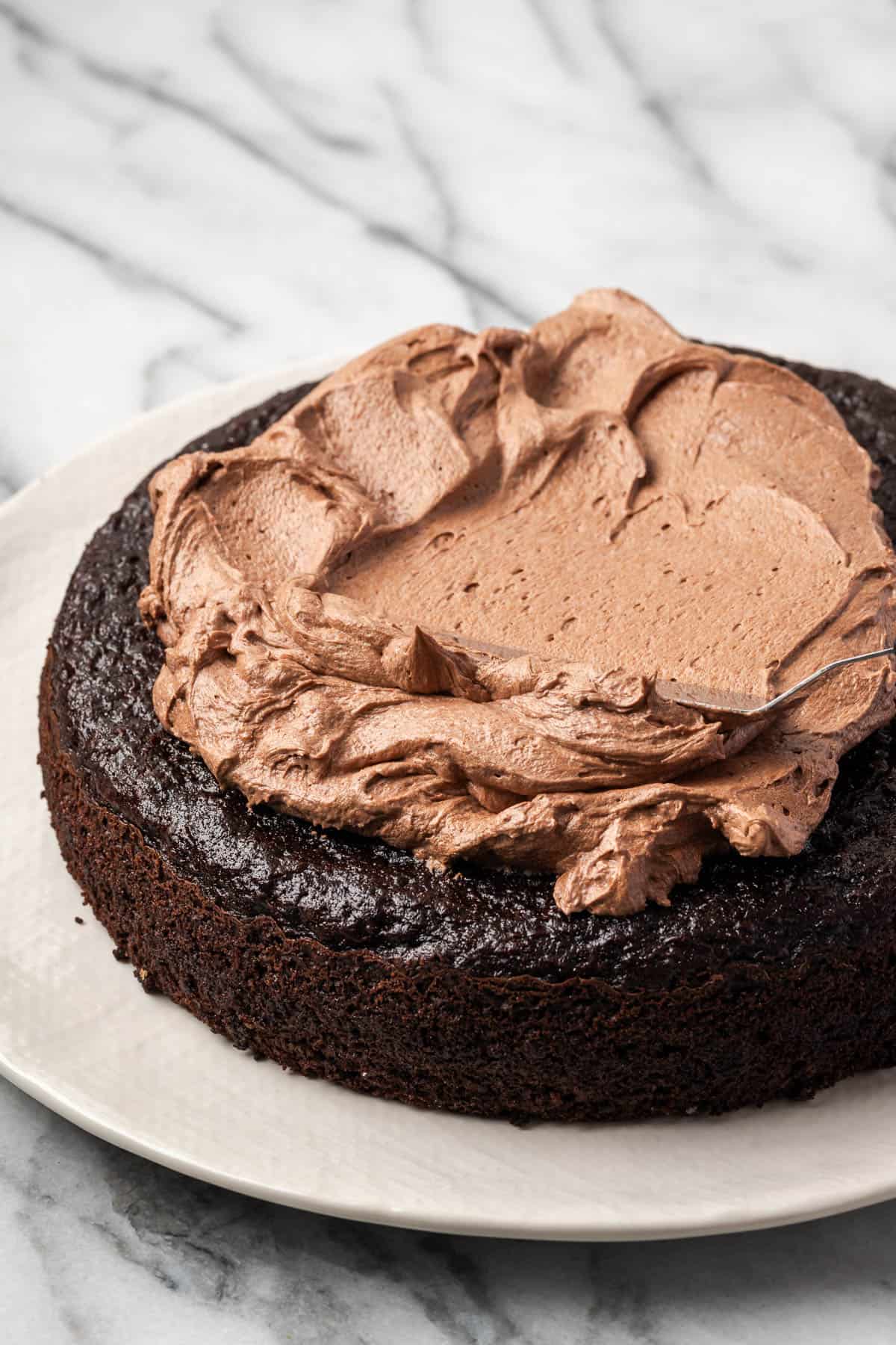 Chocolate frosting being spread onto a baked cake.