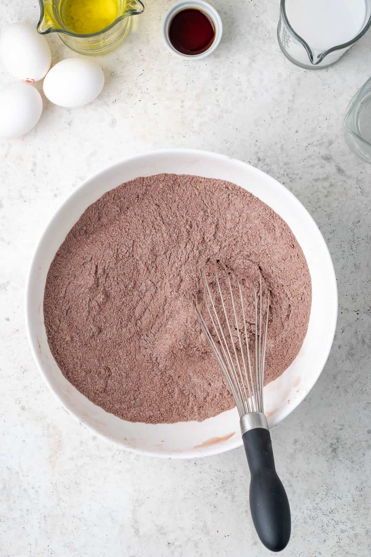 Dry ingredients being whisked together in a large mixing bowl. 