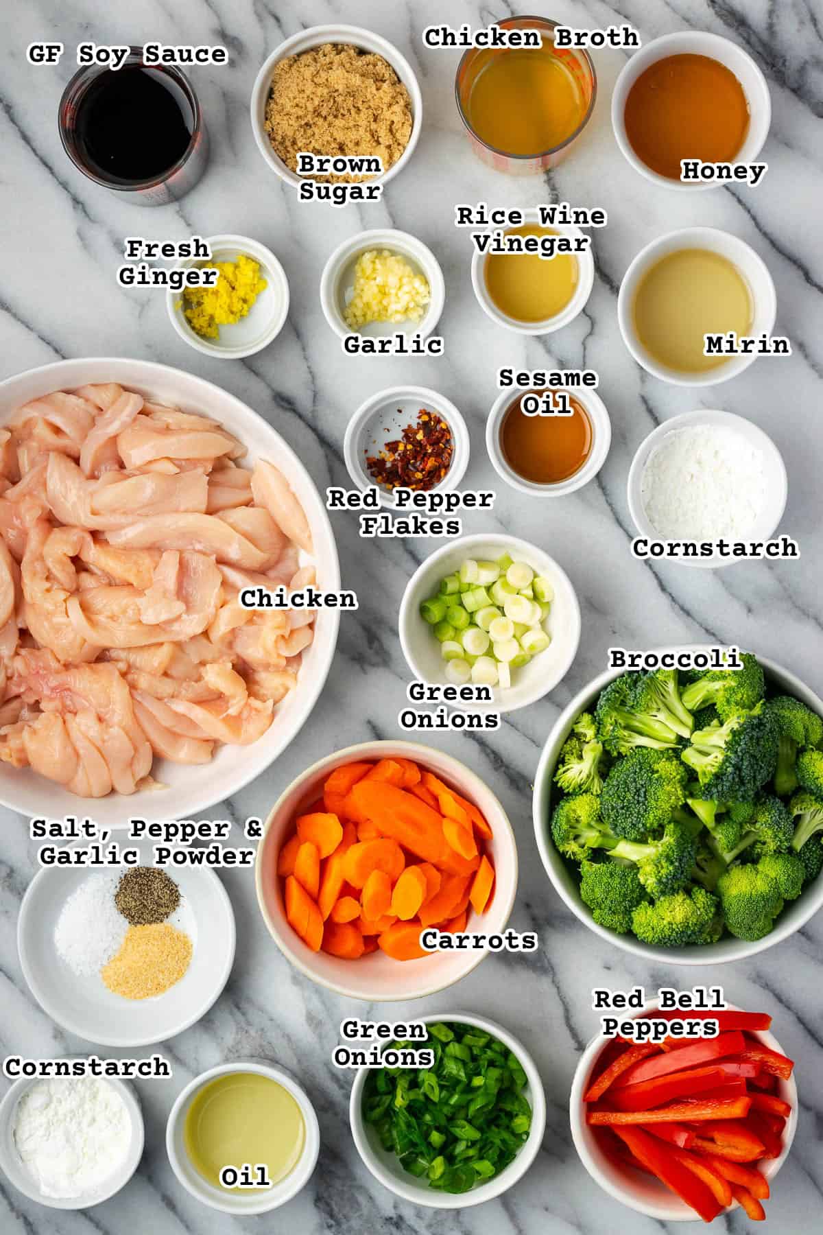 Ingredients for chicken teriyaki stir fry sitting on a marble counter. 