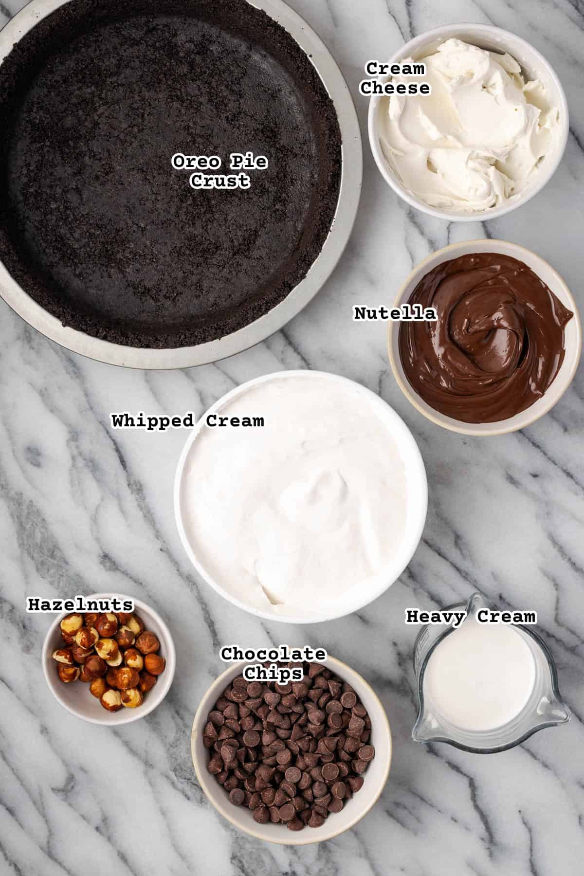 Ingredients for a no bake nutella pie sitting on a marble counter.