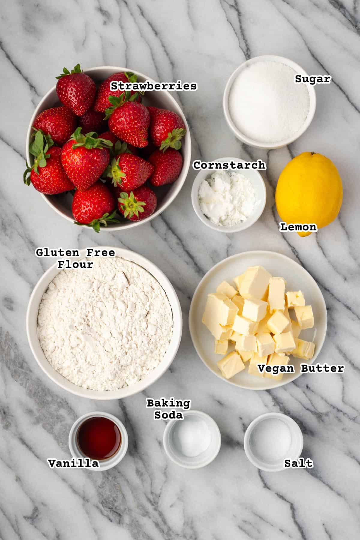 Ingredients to make strawberry crumble bars sitting on a marble counter.