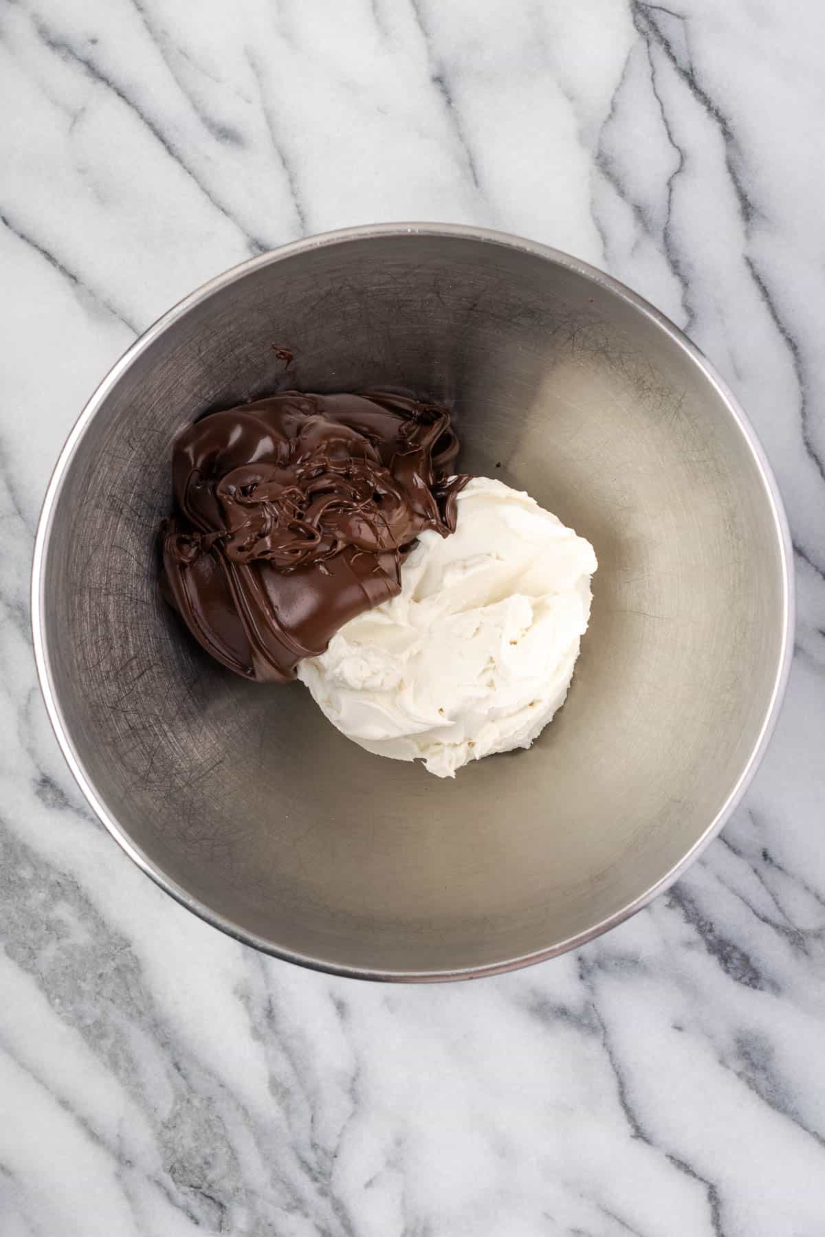 Cream cheese and Nutella combined in a large metal mixing bowl. 