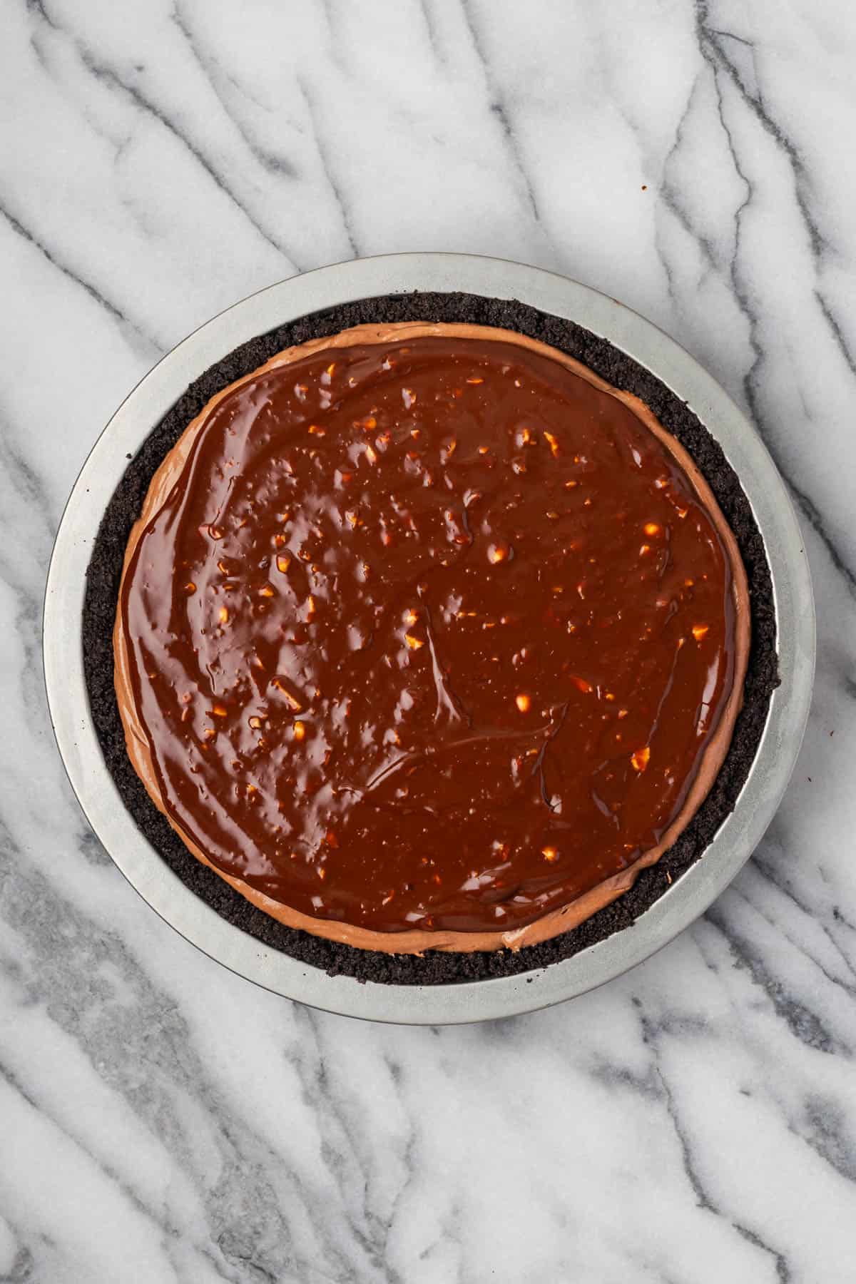 Chocolate ganache topping being spread over the Nutella pie.