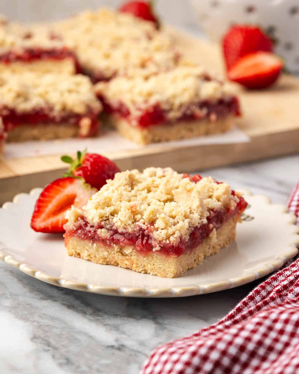 A single strawberry crumble bar on a small dessert plate.